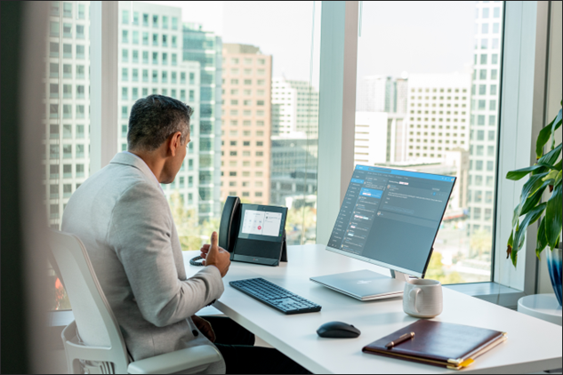 Man at office desk with a Poly phone